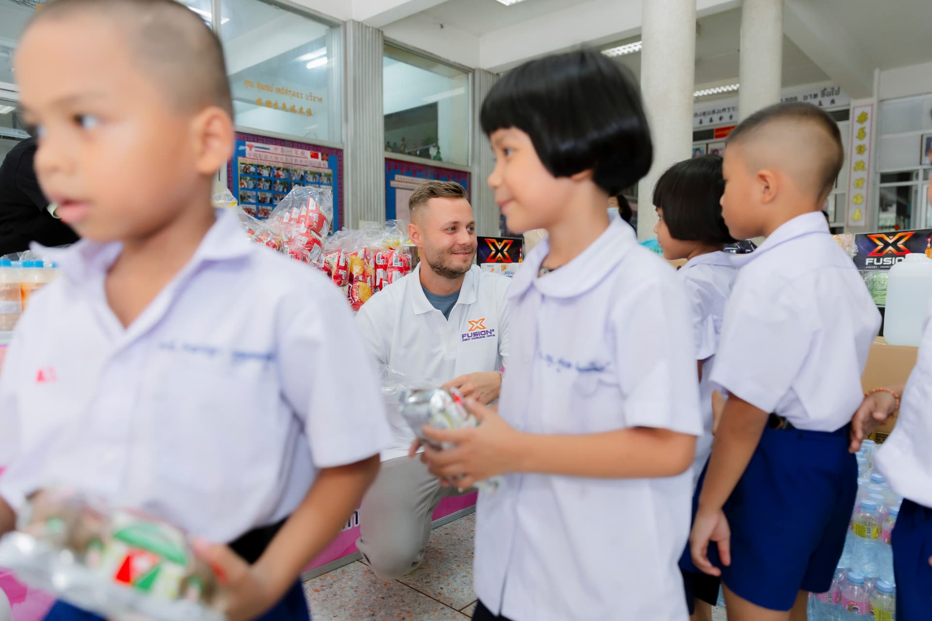 Zeljko Cikojevic with school children receiving donations at a school in Thailand